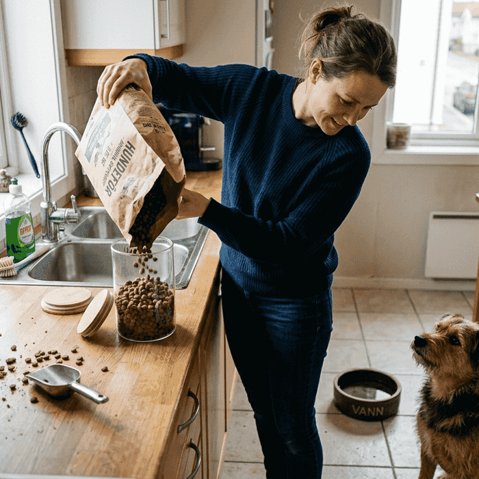 En hundeeier oppbevarer tørrfôr til hunden på kjøkkenet hjemme.