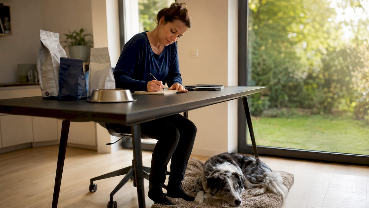 Hundeeieren skriver ned en matplan for hunden sin