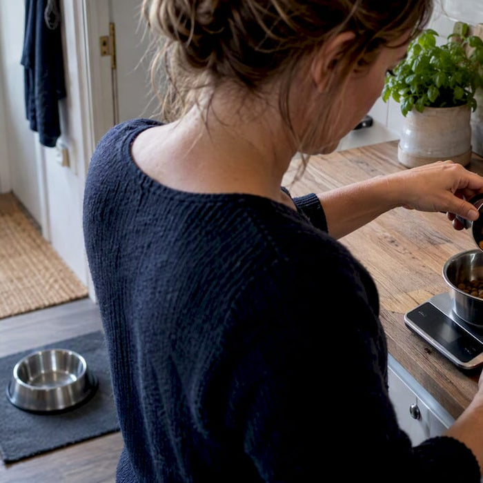 Eieren måler opp fôrmengde til hunden